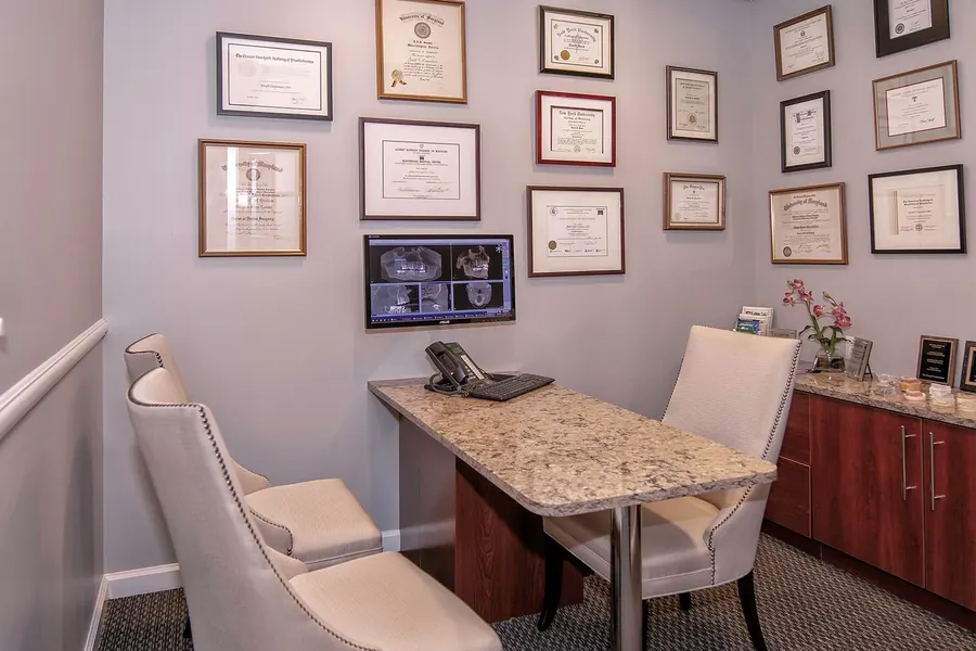 The consultation office, with diplomas on the wall and a 3D scan on the screen.