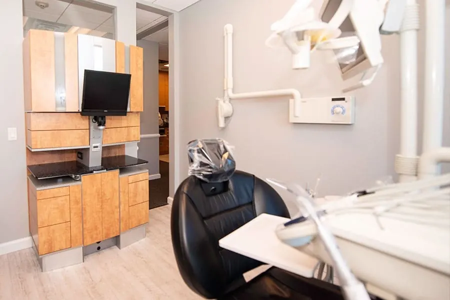 A treatment room with a monitor mounted beside the chair.